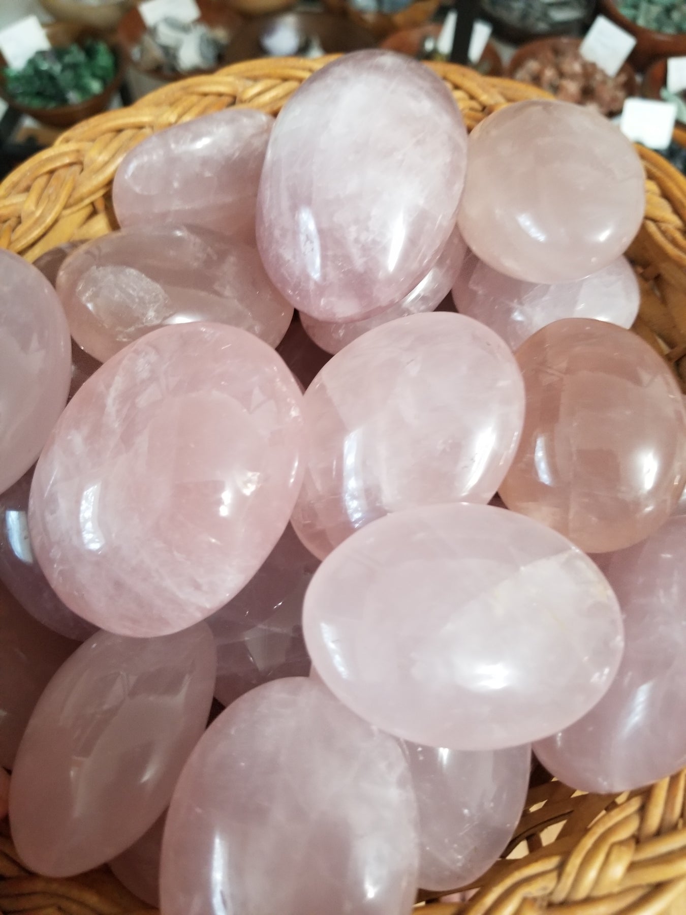 Beautifully polished palm stones (gallets) including rose quartz, labradorite, and carnelian, showcasing their unique colors and healing properties.