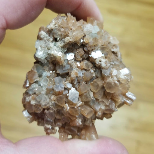Morocco’s Gem Aragonite Star Cluster showcasing intricate starburst formations with earthy hues of amber and brown.