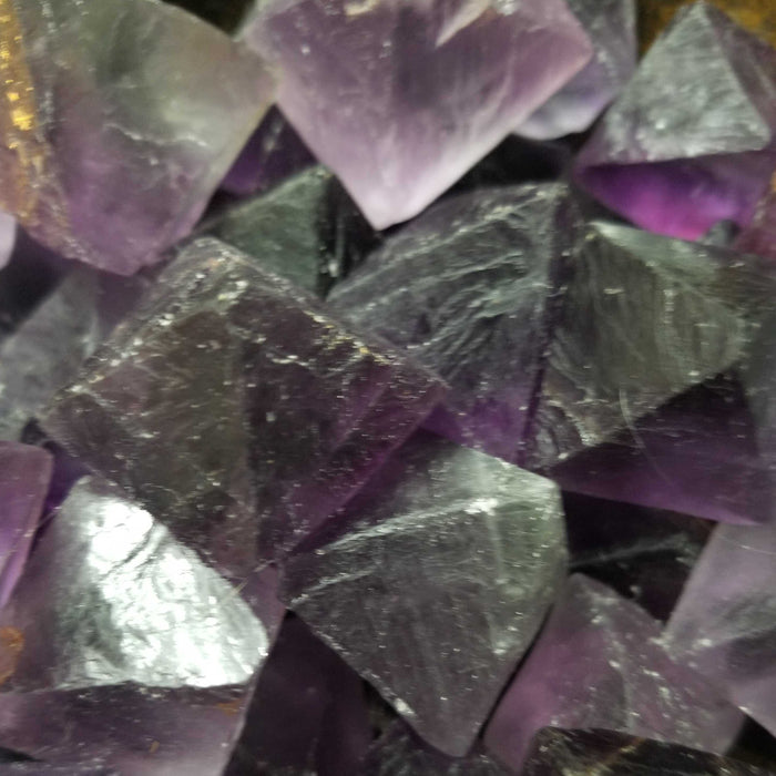 Display of multiple Fluorite Octahedrons Purple crystals, emphasizing their protective qualities and beauty in crystal healing practices.