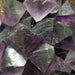 Display of multiple Fluorite Octahedrons Purple crystals, emphasizing their protective qualities and beauty in crystal healing practices.