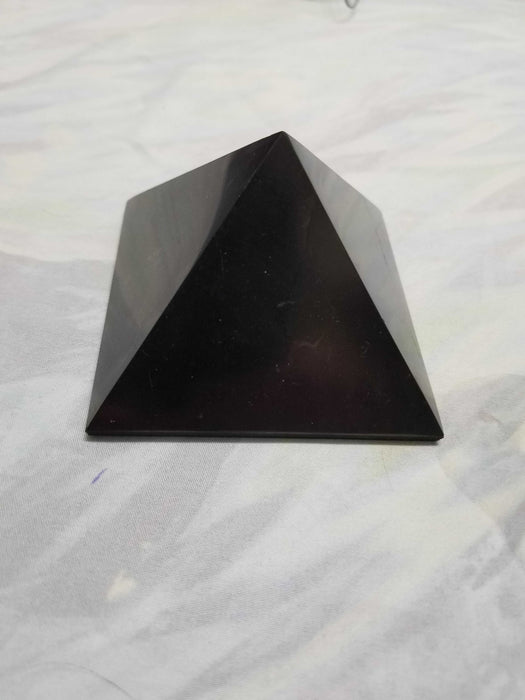 Shungite - Pyramid with various sizes available, showcasing its radius of action for EMF protection.