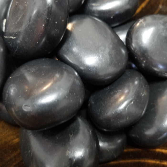 Close-up image of Shungite Palm Stones from High Ho Gems and Crystals, perfect for reducing electromagnetic emissions and transmuting EMF.