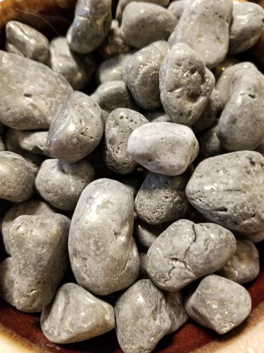 Tumbled stones featuring shimmering silver and gold hues, showcasing pyrite tumbled for crystal enthusiasts.