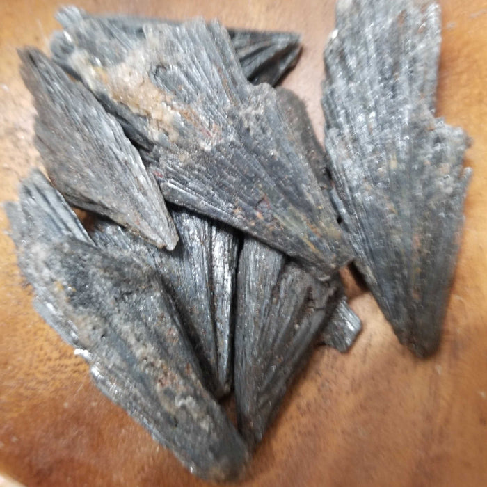 Black Kayanite raw mineral displaying its unique black color and natural crystal formations, known for its healing properties and chakra balancing abilities.