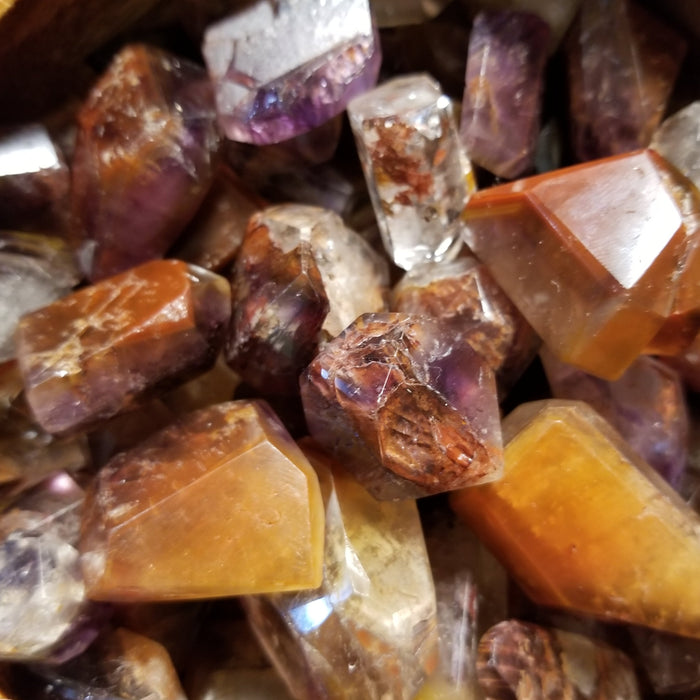 Tumbled stones - Cacoxenite Amethyst Tumbled showcasing the unique golden strands within the crystal.
