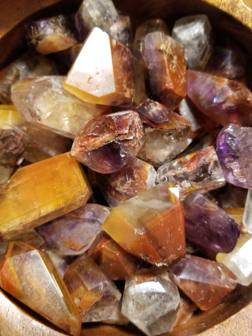 Beautifully polished Cacoxenite Amethyst Tumbled stone highlighting its rich hues of gold and brown.
