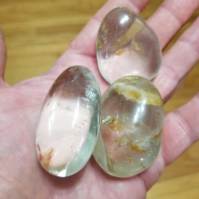 Clear Quartz palm stone from High Ho Gems and Crystals, showcasing its beautiful clarity and natural sparkle.