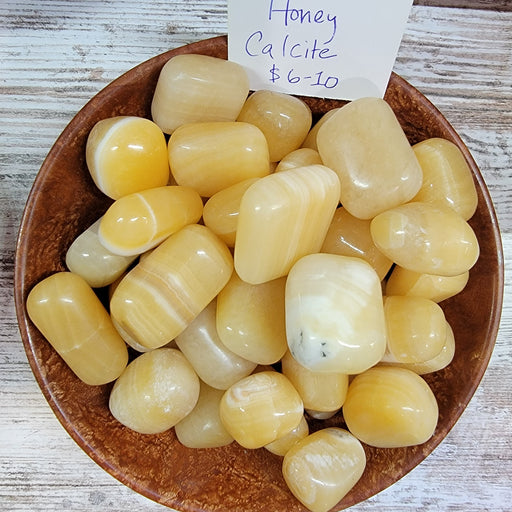 High-quality Honey Calcite tumbled stones showcasing a beautiful honey yellow color, known for enhancing memory and opening psychic potential.
