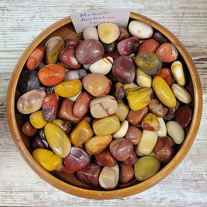 Mookaite Australian Jasper tumbled stones showcasing vibrant colors like red, burgundy, and mustard-yellow, perfect for enhancing self-confidence and grounding energy.