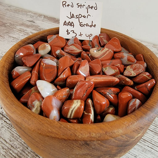 Tumbled stones showcasing AAA grade Red Stripe Jasper Tumbled, highlighting their rich red hues and unique patterns.