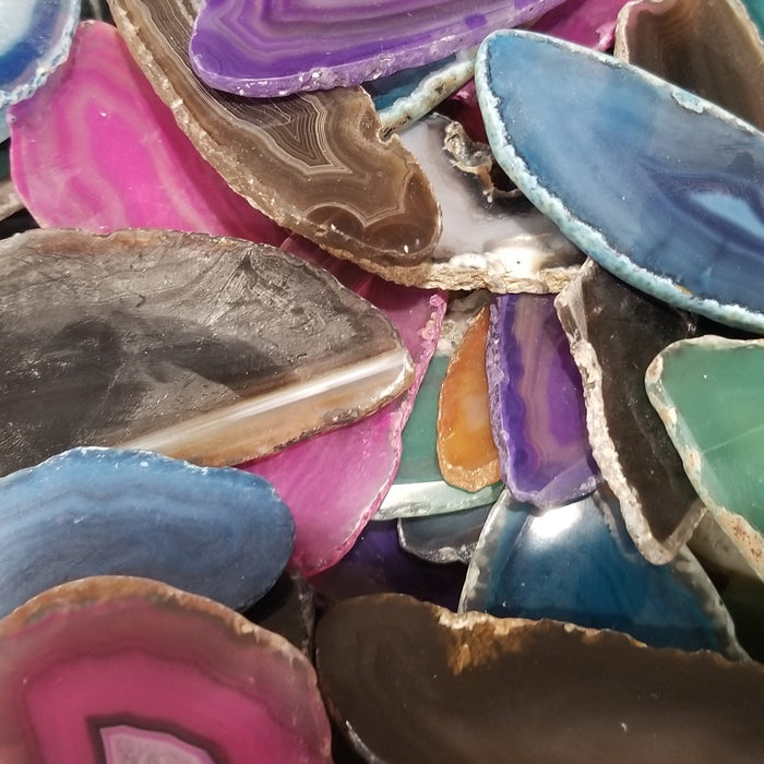 Polished Agate Slices Brazil showcasing vibrant colors in red, brown, black, blue, pink, teal, and purple.