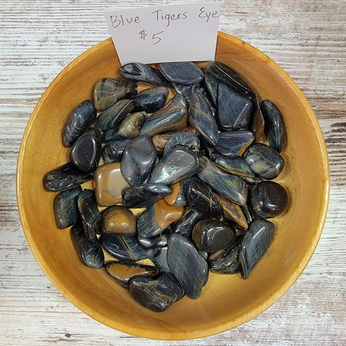 Blue Tigers Eye Tumbled stones showcasing their vibrant blue color and unique chatoyancy effects, perfect for meditation and promoting focus.