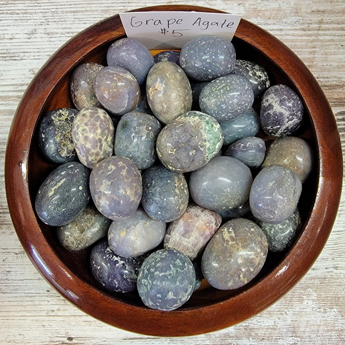 Natural Grape Agate tumbled stone showcasing its unique purple to gray color, perfect for enhancing intuition and mental clarity.