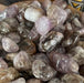 Super 7 - Melody Stone Tumbled showcasing its beautiful color variations including peach, pink, green, gray, and more.