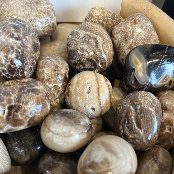 Coke Calcite tumbled stone from High Ho Gems and Crystals showcasing its unique colors and textures ideal for crystal healing and decoration.