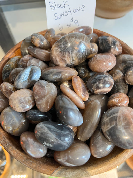 Tumbled stones - Black Sunstone, showcasing the beauty and unique texture of Black Sunstone tumbled stones, known for attracting abundance and positivity.