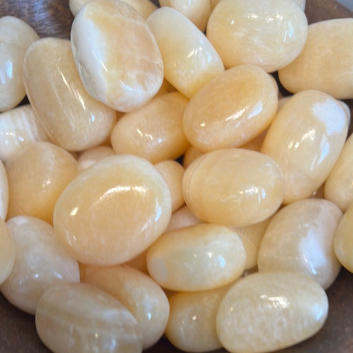 Beautiful Orange Calcite tumbled stones from Pakistan, perfect for crystal healing and decor.