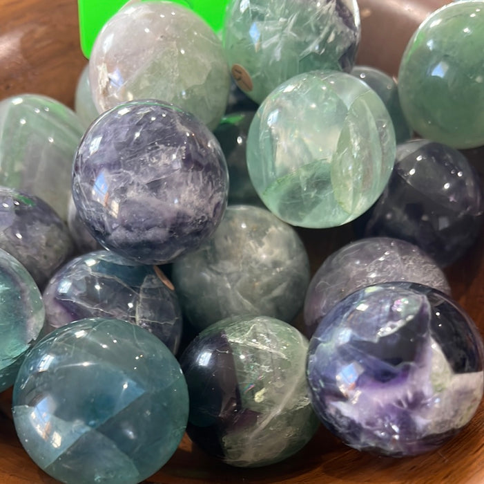 Beautifully polished Rainbow Fluorite Spheres 1 inch showcasing vibrant green, purple, and blue colors, ideal for crystal lovers.