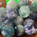 Beautifully polished Rainbow Fluorite Spheres 1 inch showcasing vibrant green, purple, and blue colors, ideal for crystal lovers.