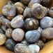 Beautiful Purple Chalcedony Tumbled stones showcasing varying shades of purple, perfect for crystal healing and decorative use.