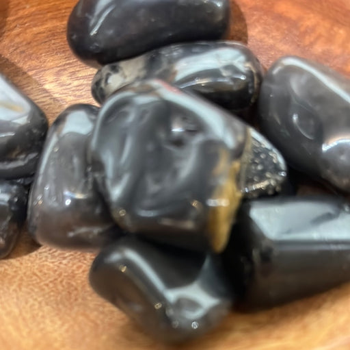 Black Onyx tumbled stone from High Ho Gems and Crystals, showcasing its sleek black to brown color range, symbolizing strength and perseverance.