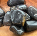 Black Onyx tumbled stone from High Ho Gems and Crystals, showcasing its sleek black to brown color range, symbolizing strength and perseverance.
